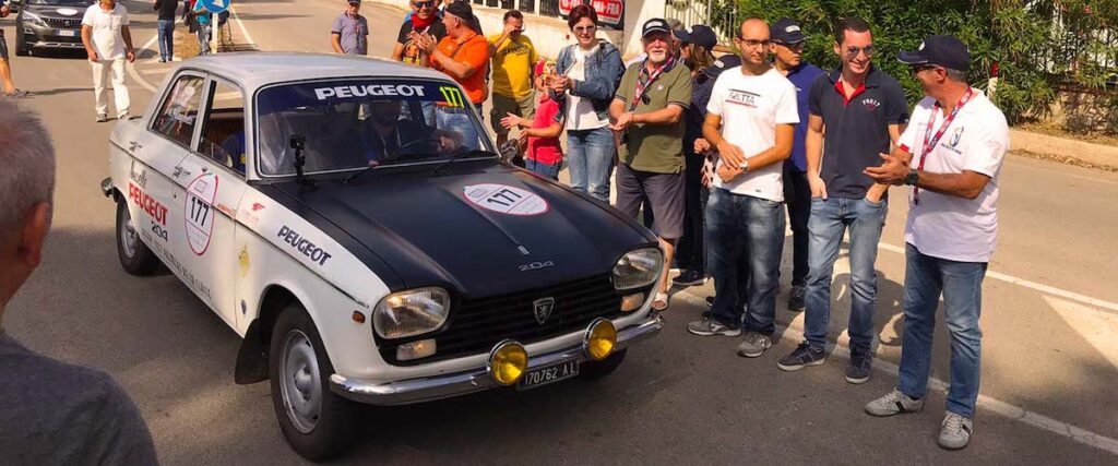 Classic Peugeot 204 Rallye at Targa Florio Live passing the historic Cerda pit lane in Sicily.